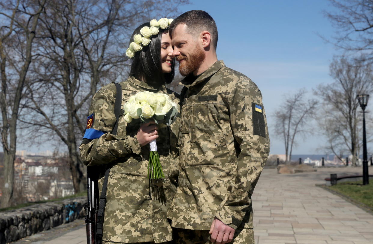 Members of the Ukrainian Territorial Defence Forces Anastasiia (24) and Viacheslav (43) react as they wait to attend their wedding ceremony, amid Russia's invasion of Ukraine, in Kyiv, Ukraine, April 7, 2022. REUTERS/Mykola Tymchenko
