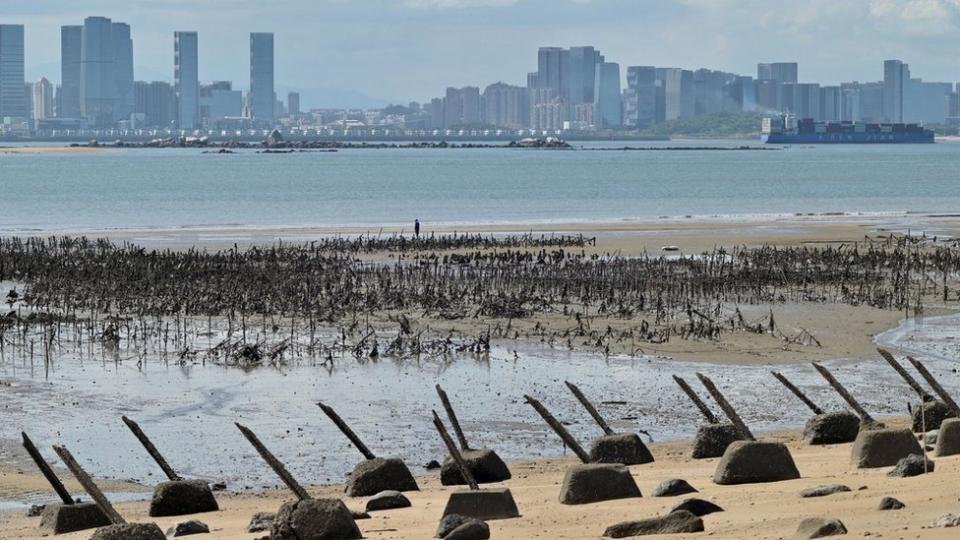 The Xiamen city skyline on the Chinese mainland is seen past anti-landing spikes placed along the coast of Lieyu islet on Taiwan's Kinmen islands, which lie just 3.2 kms (two miles) from the mainland China coast, on August 10, 2022.