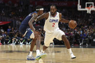 Los Angeles Clippers forward Kawhi Leonard, right, dribbles against Minnesota Timberwolves forward Jaden McDaniels during the first half of a preseason NBA basketball game, Sunday, Oct. 9, 2022, in Los Angeles. (AP Photo/Raul Romero Jr.)