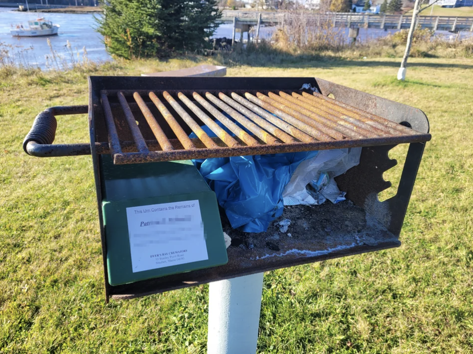 A rusty grill on the grass with a note about "Pat"