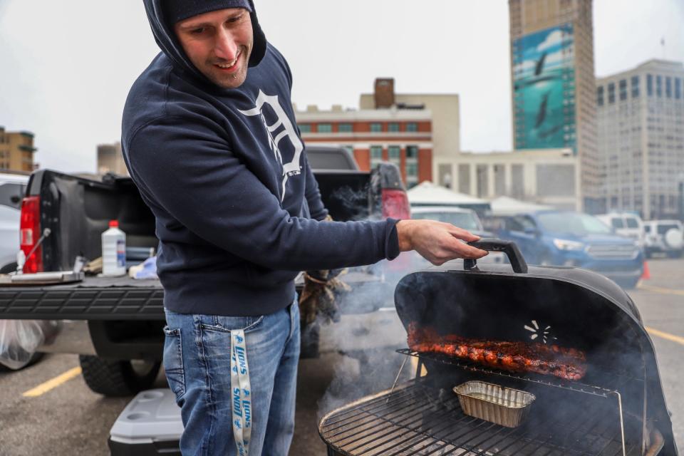 Mike Gabri, 32, of Lincoln, smokes ribs while tailgating in the parking lot, during Detroit Tigers' Opening Day at Comerica Park in Detroit on Thursday, April 4, 2019.