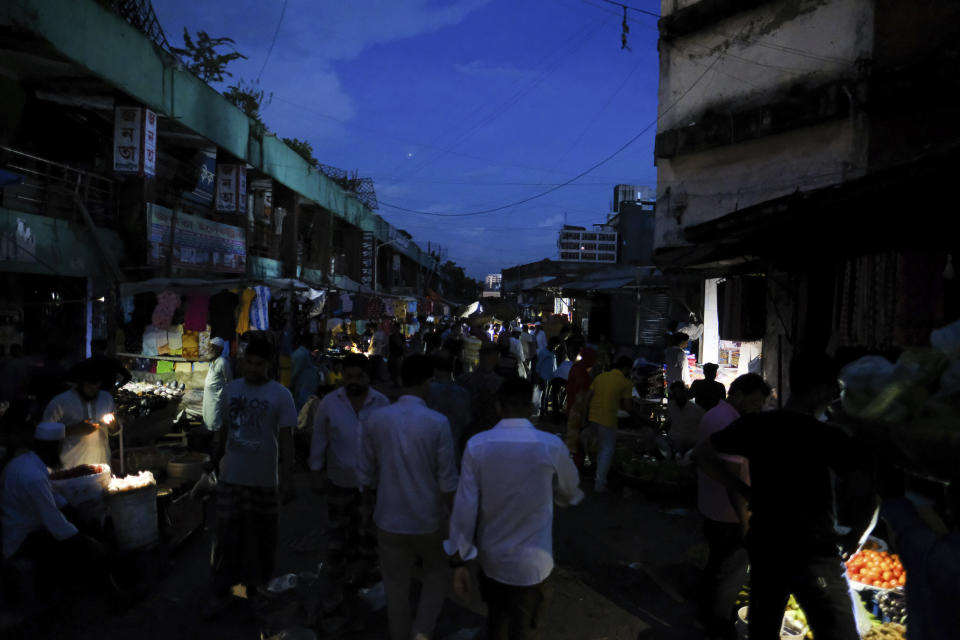 People come out of their homes during a power failure in Dhaka, Bangladesh Tuesday Oct. 4, 2022. A failure in Bangladesh's national power supply grid plunged most of the country into a blackout on Tuesday, officials said.(AP Photo/Mahmud Hossain Opu)