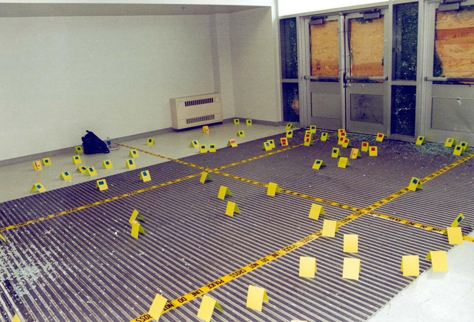 View of damage to the west entryway to Columbine High School where teenage gunmen Eric Harris and Dylan Klebold entered the school April 20, 1999 in Littleton, Colo. Flags mark points where evidence such as bullet casings were found. | Courtesy of Jefferson County Sheriff/Getty Images