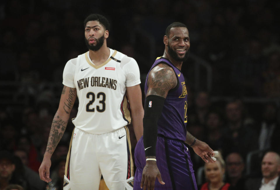 Los Angeles Lakers' LeBron James, right, smiles as he walks past New Orleans Pelicans' Anthony Davis during the first half of an NBA basketball game Friday, Dec. 21, 2018, in Los Angeles. (AP Photo/Jae C. Hong)