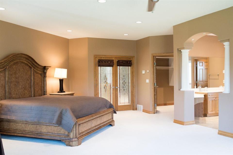 <p><span>15 Briarwood Way, Stony Plain, Alta.</span><br> Behind the French stained-glass doors, the master bedroom is spacious, and has an ensuite, a sitting area and a private balcony overlooking the golf course. There are four bedrooms in the home.<br> (Photo: Zoocasa) </p>