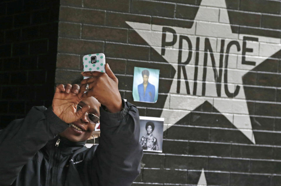 FILE - In this April 22, 2016, file photo, a fan takes a selfie by the Prince star and memorial at First Avenue in Minneapolis where he often performed. The one-year anniversary of the pop super star's death from an overdose will be marked April 21. (AP Photo/Jim Mone, File)