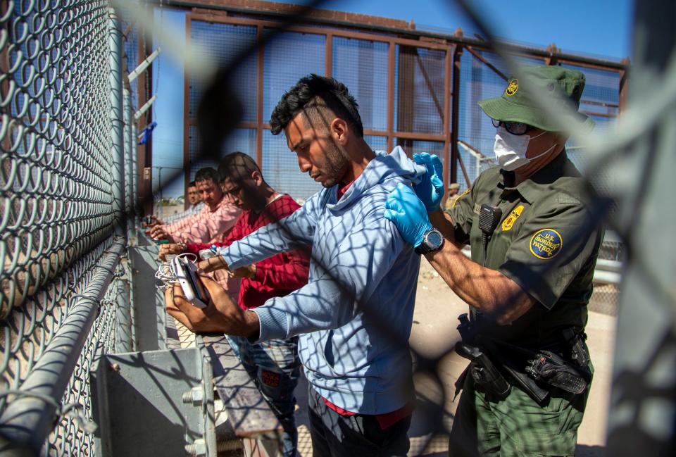 Migrants are pat down by a Border Patrol agent as they enter into El Paso, Texas from Ciudad Juarez, Mexico,  on Wednesday.
