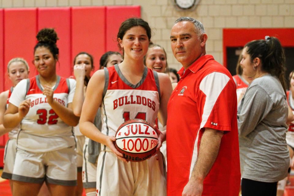 Julz Mohrbacher and Freedom coach John Kaercher pose with her basketball that says 'Julz, 1,000 Points" after scoring her 1,000th point in Freedom's victory Jan. 17 against New Brighton at Freedom High School.