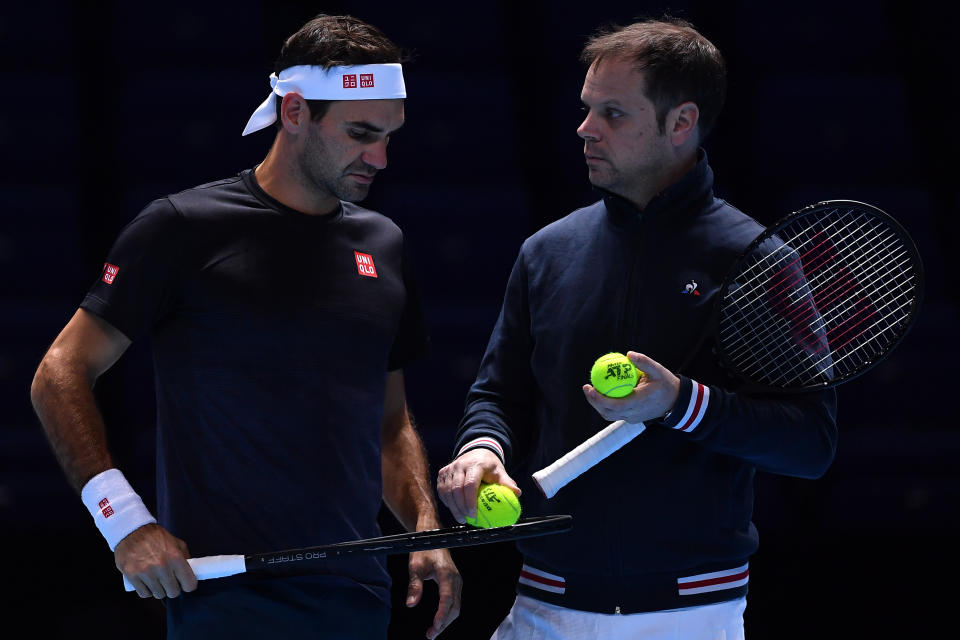 Roger Federer and coach Severin Luthi talk during practice.