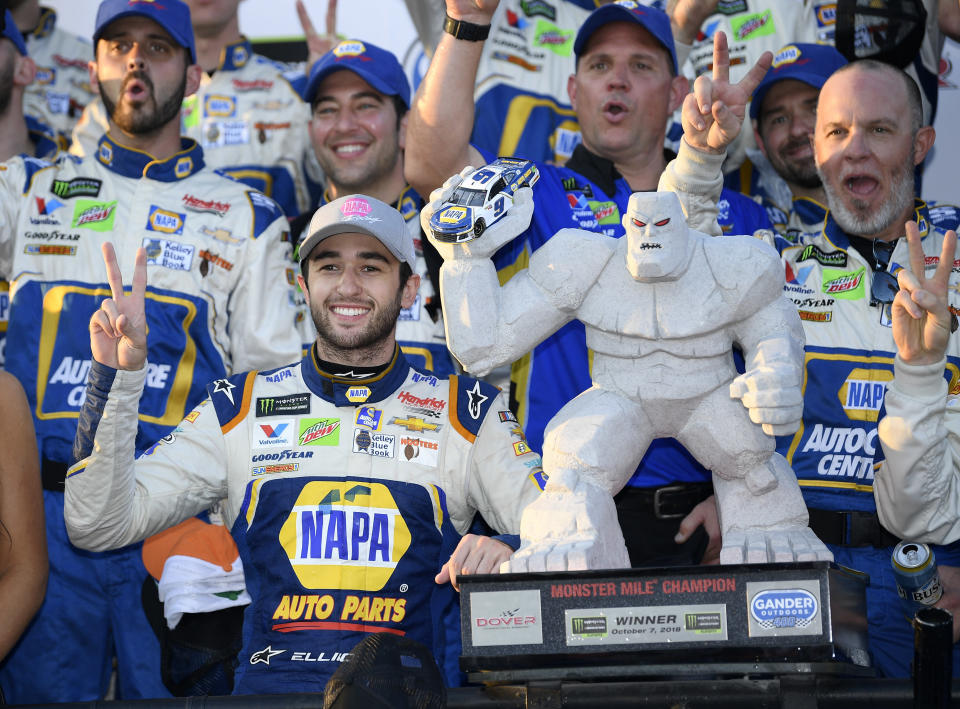 Chase Elliott, front left, poses with the trophy in Victory Lane after he won a NASCAR Cup Series auto race, Sunday, Oct. 7, 2018, at Dover International Speedway in Dover, Del. (AP Photo/Nick Wass)