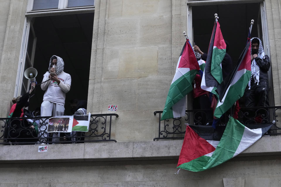 Students blocking Sciences-Po university display Palestinian flags, in Paris Friday, April 26, 2024. Students in Paris inspired by Gaza solidarity encampments at campuses in the United States blocked access to a campus building at a prestigious French university Friday, prompting administrators to move all classes online. The pro-Palestinian protest at the Paris Institute of Political Studies, known as Sciences Po, came two days after police broke up a separate demonstration at one of the university's amphitheaters. (AP Photo/Michel Euler)