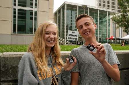 Taylor Swift fans (L-R) Avery Tellam and Jackson Horan display their numbers that will allow them into Denver Federal Court where the Taylor Swift groping trial jury selection is to resume in Denver, U.S., August 8, 2017. REUTERS/Rick Wilking