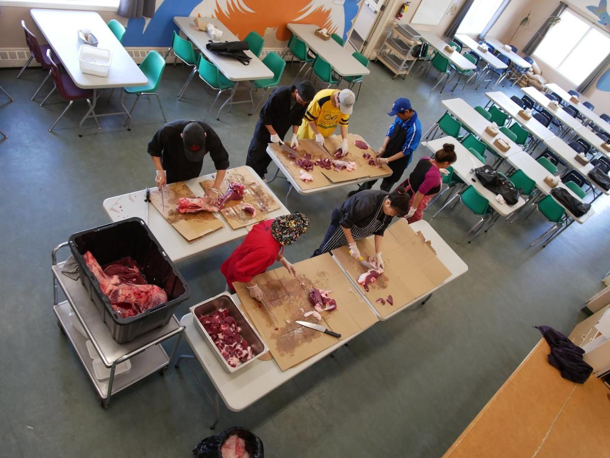 People prepare to distribute food at the Qajuqturvik Community Food Centre in Iqaluit. The centre's co-executive director wants to see country food included in a national school food program.  (Submitted by Rachel Blais - image credit)