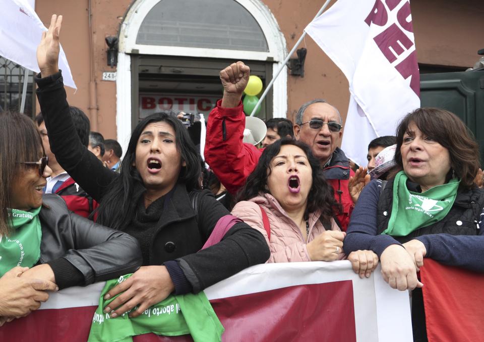 Pedestrians walking past stop spontaneously to shout at lawmakers outside Congress, in Lima, Peru, Monday, Sept. 30, 2019. The political duel between Peruvian President Martin Vizcarra and Congress intensified in recent weeks after lawmakers decided to shelve Vizcarra's proposal to hold early presidential and congressional elections, which he argues is necessary to break the deadlock and stabilize the nation. (AP Photo/Martin Mejia)