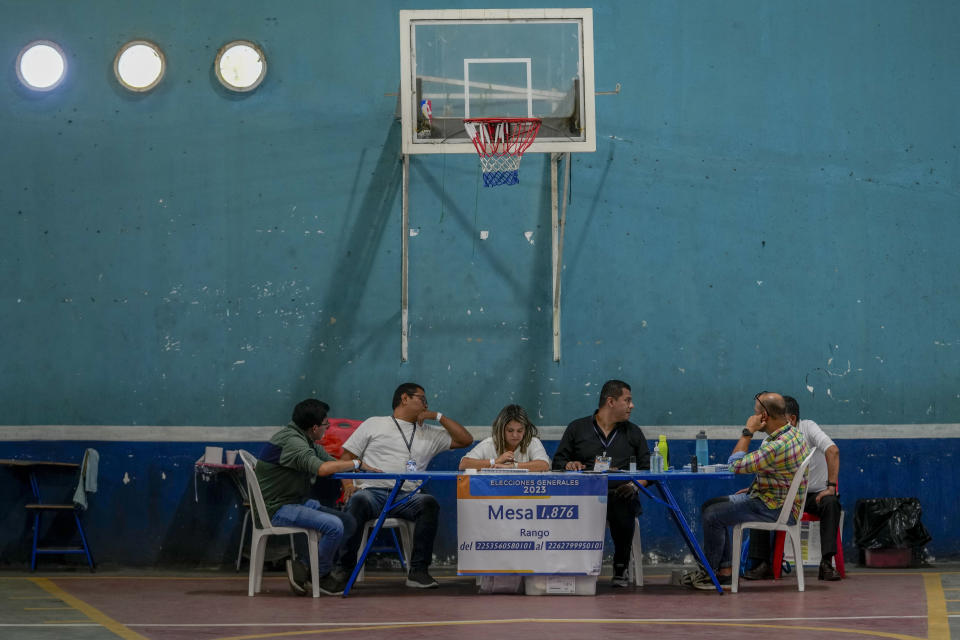 Electoral officials sit at a polling station during a run-off presidential election in Guatemala City, Sunday, Aug. 20, 2023. (AP Photo/Moises Castillo)