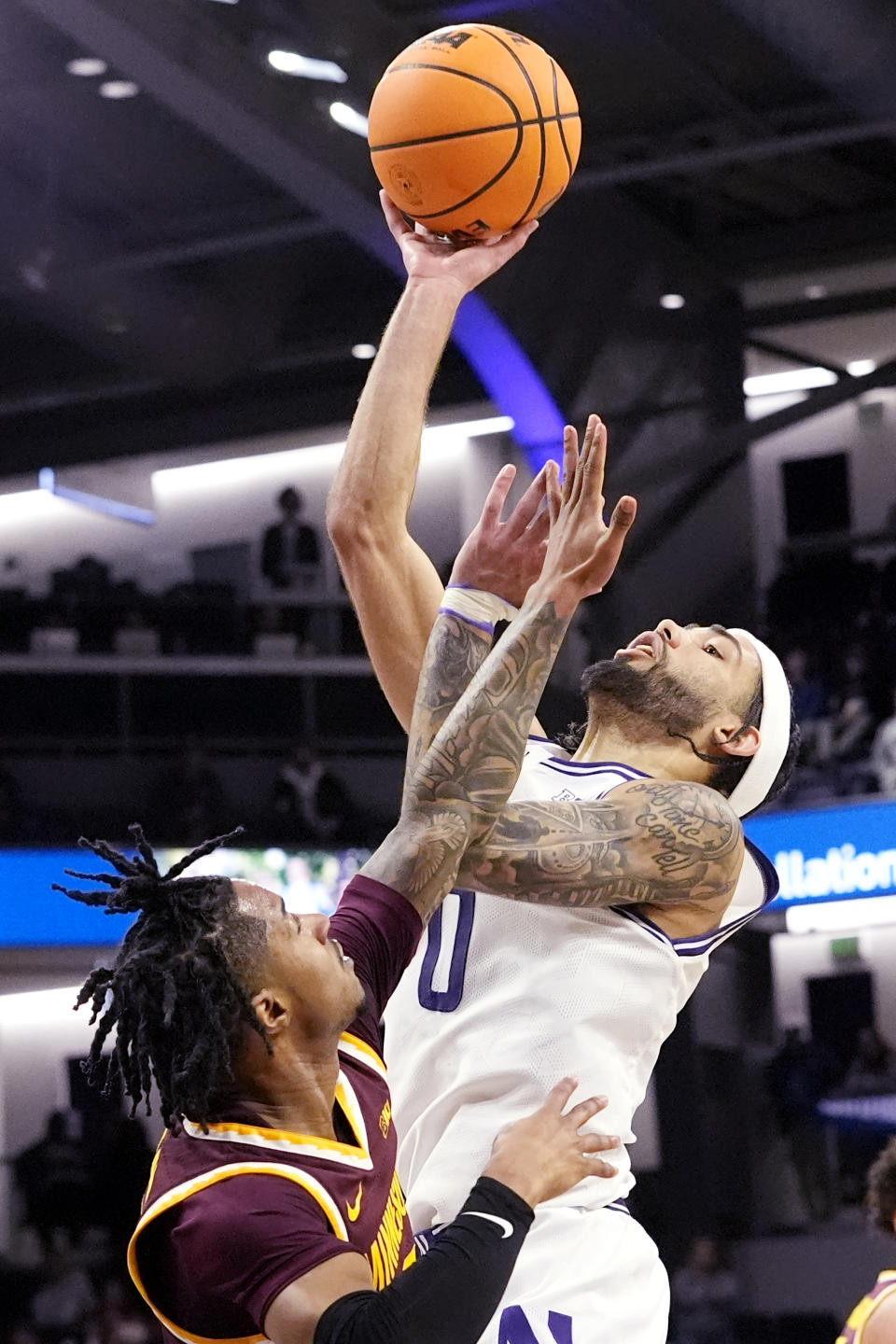 Northwestern guard Boo Buie, right, shoots over Minnesota guard Elijah Hawkins, left, during the second half of an NCAA college basketball game in Evanston, Ill., Saturday, March 9, 2024. Northwestern won 90-66. (AP Photo/Nam Y. Huh)