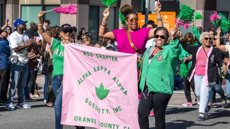 Members of the Alpha Kappa Alpha Sorority, Inc. of Orange County wave to parade goers along Anaheim Boulevard during the 43rd annual Orange County Black History Parade & Unity Fair on Saturday, February 4, 2023 in Anaheim.