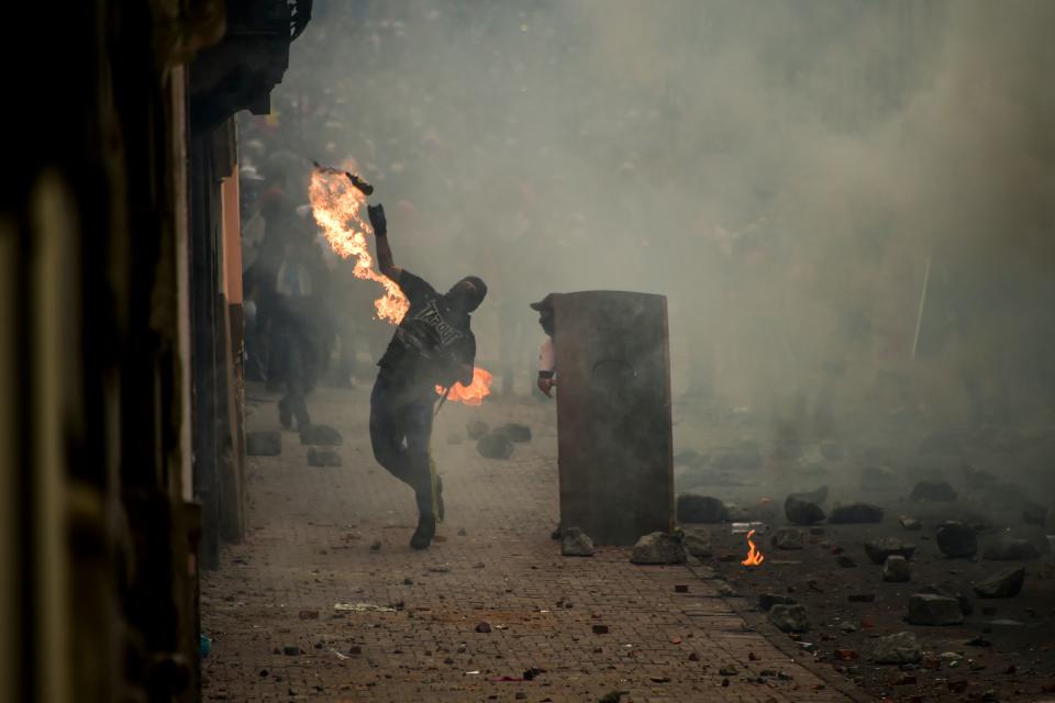 A demonstrator throws a Molotov cocktail at riot police during clashes in Quito, as thousands march against Ecuadorean President Lenin Moreno's decision to slash fuel subsidies, on Oct. 9, 2019. (Photo: Rodrigo Buendia/AFP via Getty Images)