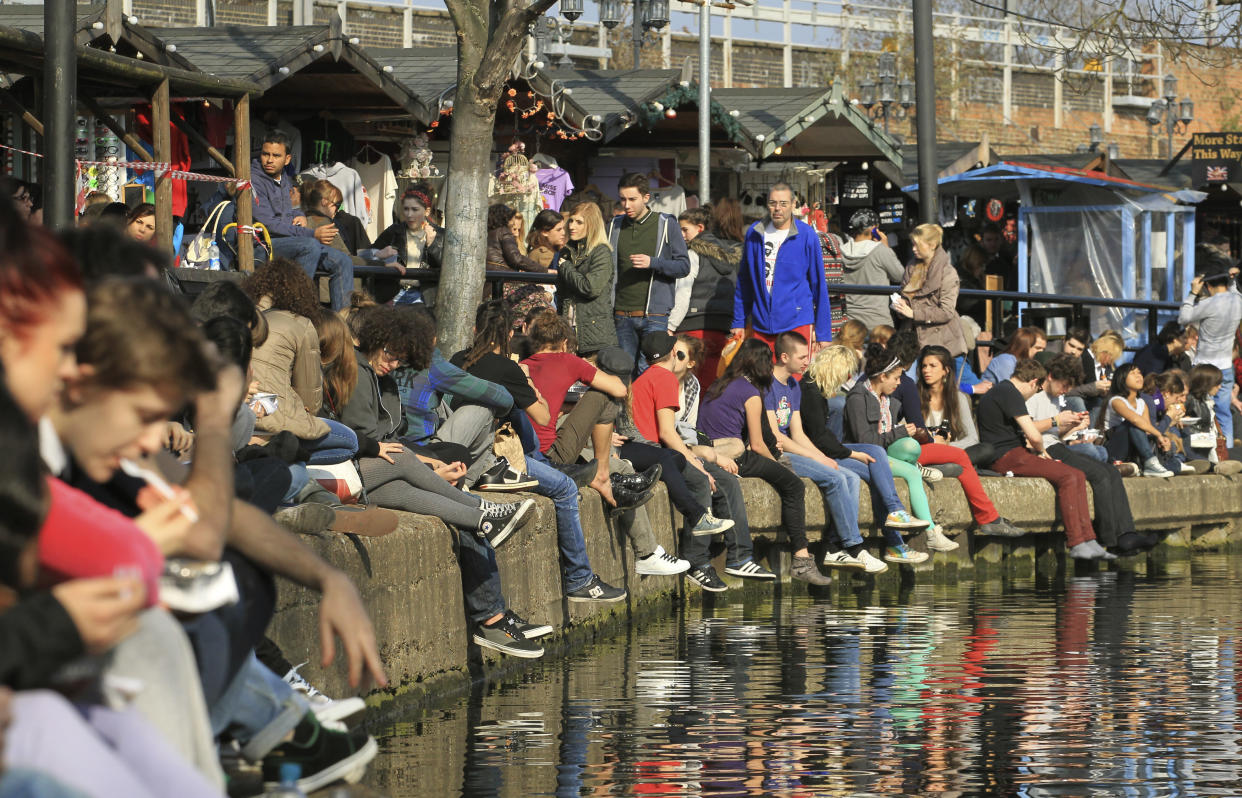 People sit in the sunshine along the canal in Camden, north London March 11, 2012. REUTERS/Olivia Harris (BRITAIN - Tags: SOCIETY)