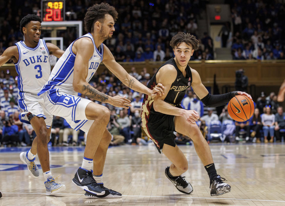 Florida State's Jalen Warley, right, handles the ball as Duke's Dereck Lively II, left, defends during the first half of an NCAA college basketball game in Durham, N.C., Saturday, Dec. 31, 2022. (AP Photo/Ben McKeown)