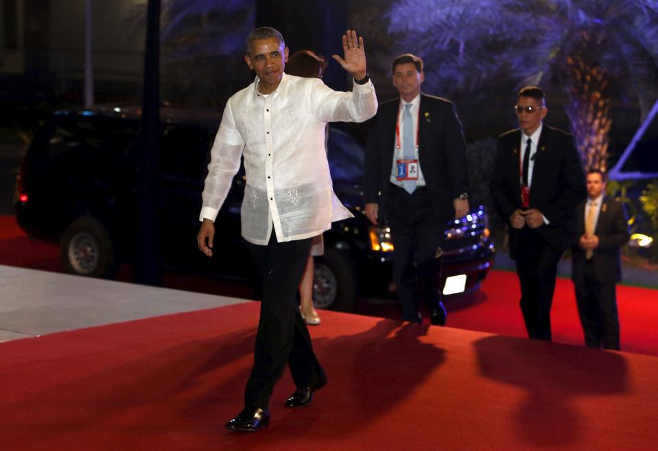 U.S. President Barack Obama, wearing the traditional Philippine "barong", waves as he arrives for a welcome dinner during the Asia-Pacific Economic Cooperation (APEC) summit in Manila