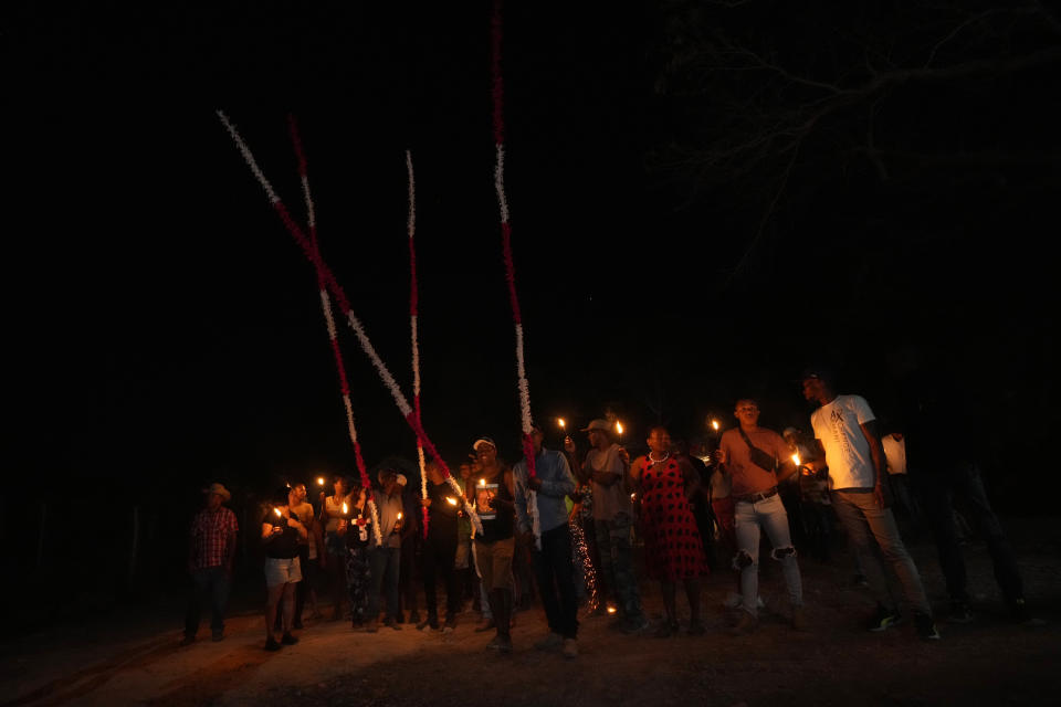 A member of the Kalunga quilombo, the descendants of runaway slaves, take part in the candlelight procession during the culmination of the week-long pilgrimage and celebration for the patron saint "Nossa Senhora da Abadia" or Our Lady of Abadia, in the rural area of Cavalcante in Goias state, Brazil, Saturday, Aug. 13, 2022. (AP Photo/Eraldo Peres)