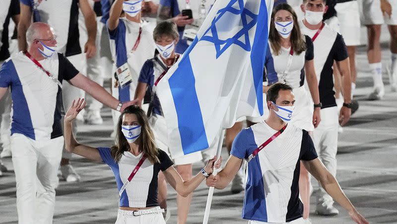 Hanna Minenko and Yakov Toumarkin, of Israel, carry their country’s flag during the opening ceremony in the Olympic Stadium at the 2020 Summer Olympics on July 23, 2021, in Tokyo, Japan. Tensions between Russia and the International Olympic Committee are ratcheting up again over a new warning from Olympic officials about discriminating against Israeli athletes as war rages in Gaza.