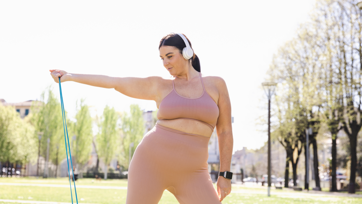  Woman doing a resistance band workout in the park 