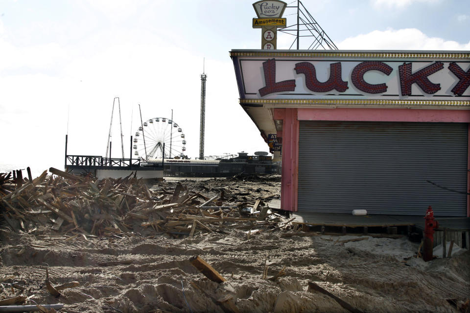 FILE - In this Thursday, Nov. 22, 2012 file photograph, debris left by Superstorm Sandy lay where the boardwalk had been in front of Lucky Leo's arcade in Seaside Heights, N.J. Visitors to the Jersey shore this Memorial Day weekend will find many of their favorite beaches and boardwalks ready for summer, thanks to a massive rebuilding effort after Superstorm Sandy. While several neighborhoods remain damaged, all but one of the storm-wrecked boardwalks should be ready for Memorial Day weekend, and amusement rides will still be available from Keansburg to Wildwood. Most beaches will be open, despite losing sand during the storm. (AP Photo/Mel Evans, File)