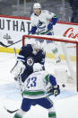 Vancouver Canucks' Brock Boeser (6) and Oliver Ekman-Larsson (23) watch as J.T. Miller's (9) shot gets past Winnipeg Jets goaltender Connor Hellebuyck (37) during the first period of an NHL hockey game, Thursday, Jan. 27, 2022 in Winnipeg, Manitoba. (John Woods/The Canadian Press via AP)