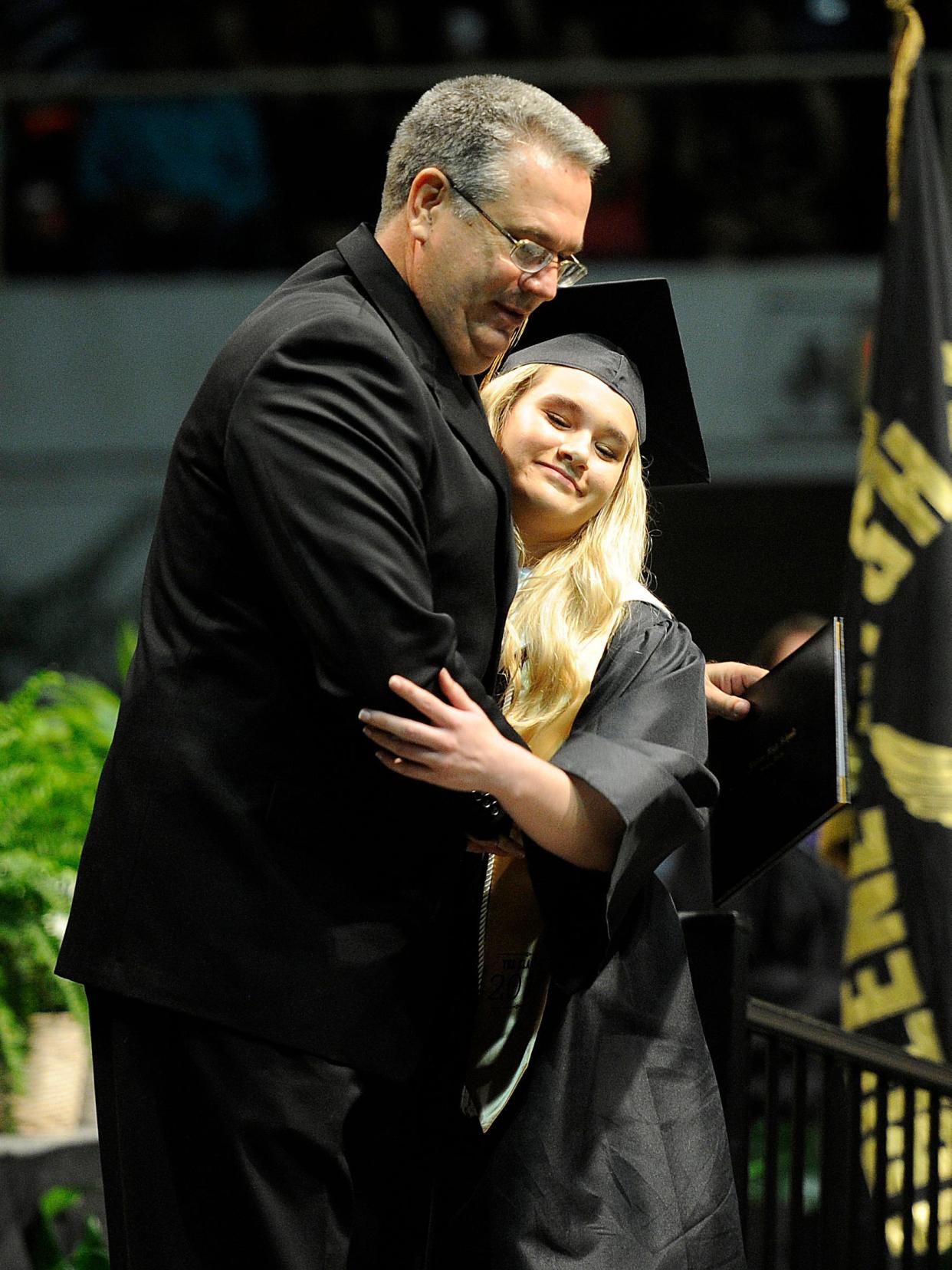 Abilene ISD athletic director Phil Blue hugs his daughter, Alyssa, as she walks across the stage during the Abilene High School graduation ceremony on May 27, 2017. (Thomas Metthe)