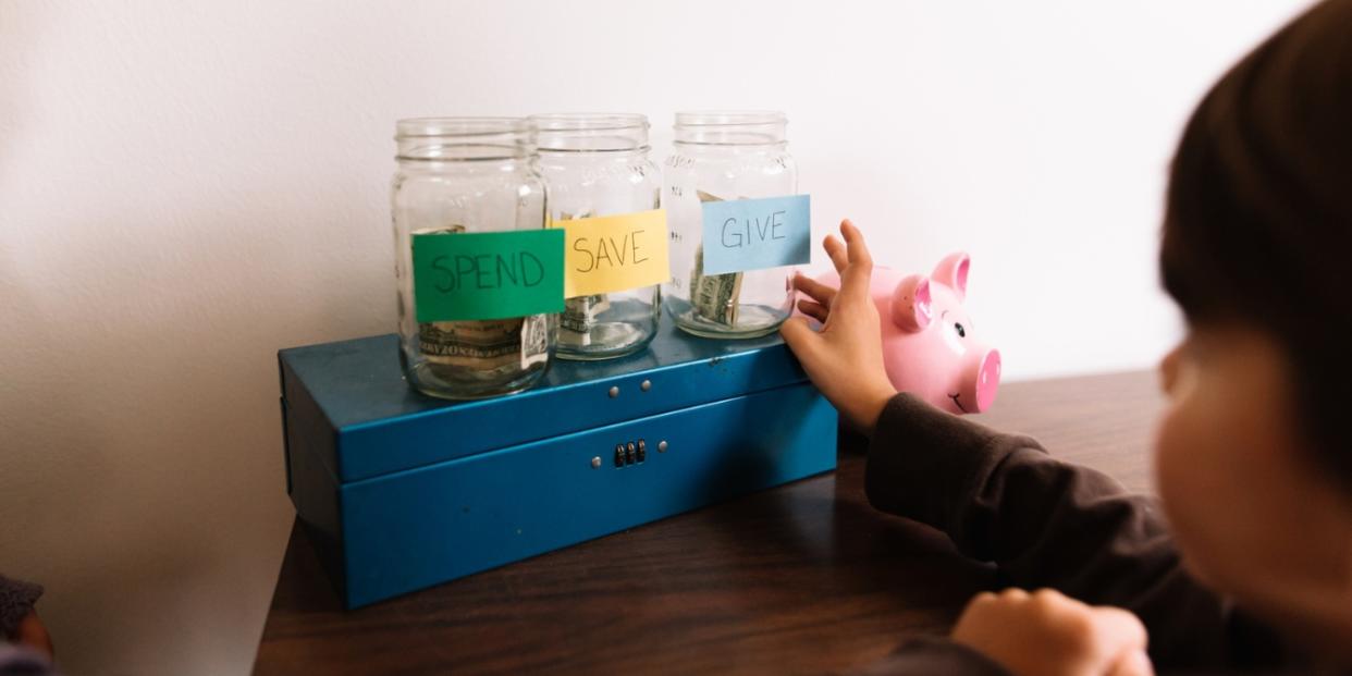 child with money jars budgeting