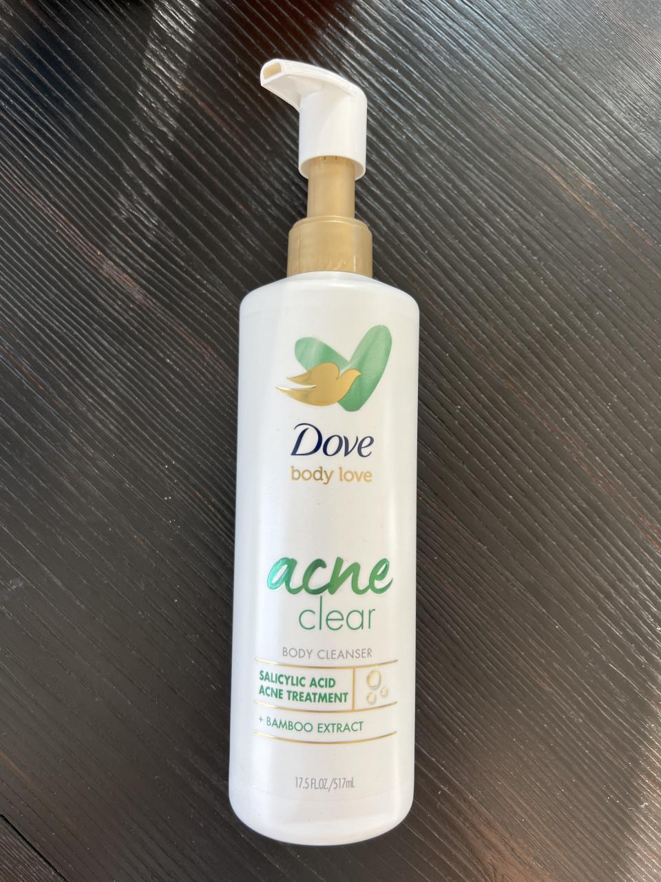 a bottle of the dove body love acne clear body cleanser resting on the table