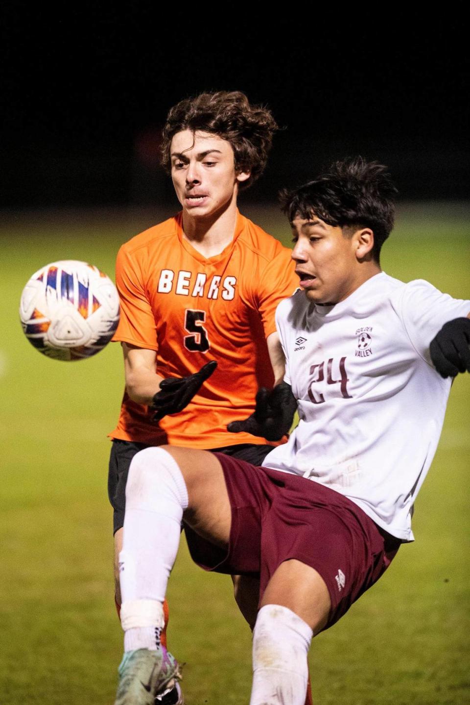 Merced senior Antonio Hight (5) and Golden Valley junior Jose Ontiveros (24) battle for possession of the ball during a game at Merced High School in Merced, Calif., on Thursday, Jan. 11, 2024. The Cougars beat the Bears 3-1.