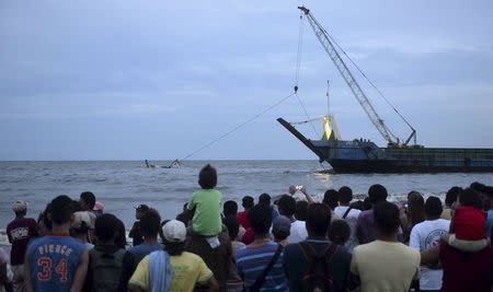 Residents and relatives of victims watch members of the Philippine Coast Guard attempting to recover the remains of the capsized vessel MBCA Kim-Nirvana during a search and rescue operations near a port in Ormoc city, central Philippines July 2, 2015. REUTERS/Alan Kristofer Motus