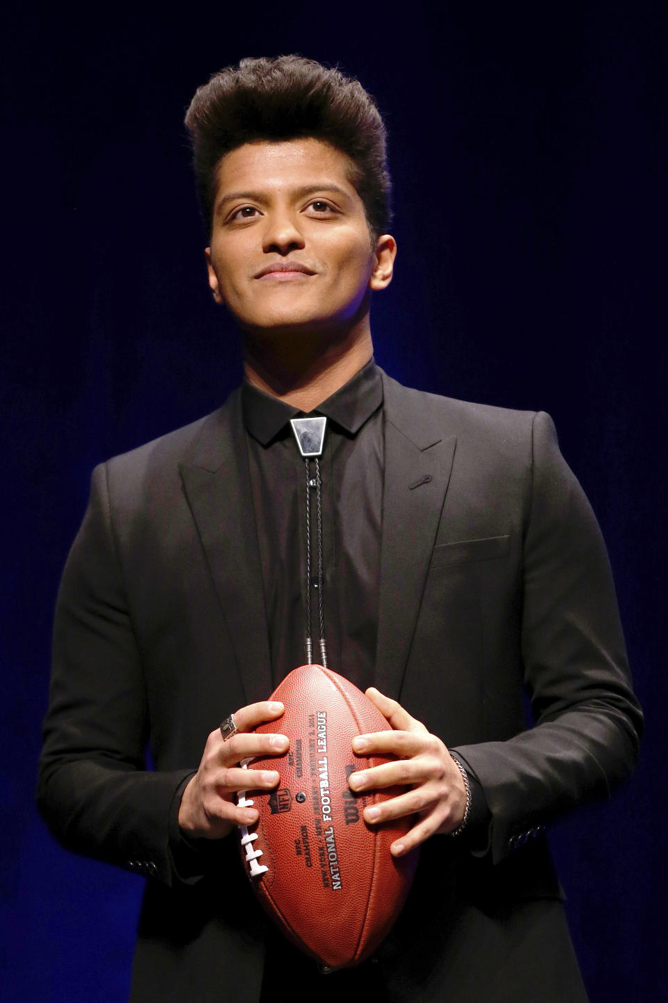 Bruno Mars who will headline the half-time show at the NFL Super Bowl XLVIII football game hold the game ball during a press conference Thursday, Jan. 30, 2014, in New York. (AP Photo/)