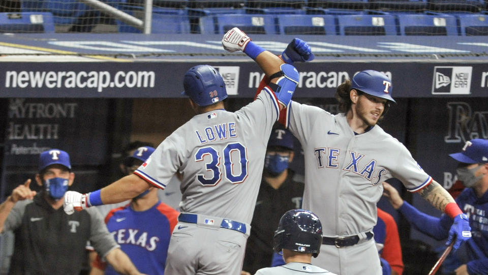 Texas Rangers' Nate Lowe (30) celebrates his solo home run off Tampa Bay Rays starter Josh Fleming with Jonah Heim, right, during the second inning of a baseball game Wednesday, April 14, 2021, in St. Petersburg, Fla. (AP Photo/Steve Nesius)