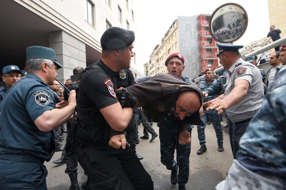 TOPSHOT - Police officers detain opposition supporters blocking the Armenian Foreign Ministry building during anti-government demonstrations in the capital Yerevan on May 24, 2022. - Yerevan has been gripped by anti-government protests since mid-April, with opposition parties demanding Prime Minister Nikol Pashinyan's resignation over his handling of a territorial dispute with Azerbaijan. Arch-foes Armenia and Azerbaijan fought two wars -- in 2020 and in the 1990s -- over the long-contested region of Nagorno-Karabakh. Six-weeks of fighting in autumn 2020 claimed more than 6,500 lives and ended with a Russian-brokered ceasefire agreement. Under the deal, Armenia ceded swathes of territory it had controlled for decades, and Russia deployed some 2,000 peacekeepers to oversee the truce. (Photo by Karen MINASYAN / AFP) (Photo by KAREN MINASYAN/AFP via Getty Images)