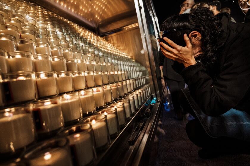 JERUSALEM, ISRAEL -- NOVEMBER 6, 2023: A woman weeps in her hands as mourners gather for a candlelight vigil to honor the 1400 Israelis killed and to mark the 30th day since the unprecedented Oct. 7th Hamas assault on communities near Gaza, during a special ceremony at the Western Wall in the Old City in Jerusalem, Israel, Monday, Nov. 6, 2023. Israeli authorities say that 1,400 people were killed in the Hamas attack, and 240 are still held hostage. (MARCUS YAM / LOS ANGELES TIMES)