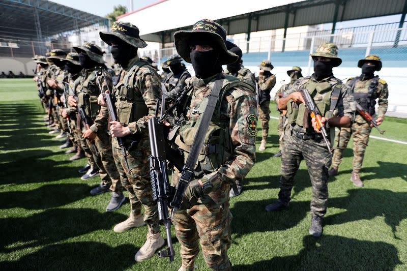 Palestinian Islamic Jihad militants gather at a mourning house amid ceasefire