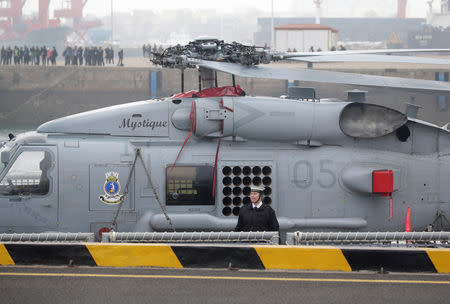 A Royal Australian Navy personnel stands next to a military helicopter as the Adelaide class guided missile frigate HMAS Melbourne (III) arrives at Qingdao Port for the 70th anniversary celebrations of the founding of the Chinese People's Liberation Army Navy (PLAN), in Qingdao, China April 21, 2019. REUTERS/Jason Lee