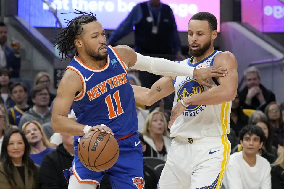 New York Knicks guard Jalen Brunson (11) drives to the basket against Golden State Warriors guard Stephen Curry during the first half of an NBA basketball game in San Francisco, Monday, March 18, 2024. (AP Photo/Jeff Chiu)