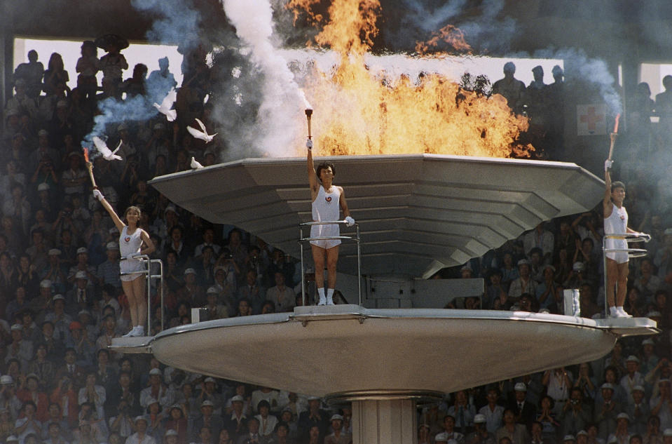 Pigeons fly around as the Olympic torch is lit during opening ceremonies in Seoul Sept. 17, 1988. (AP Photo/Michel Lipchitz)