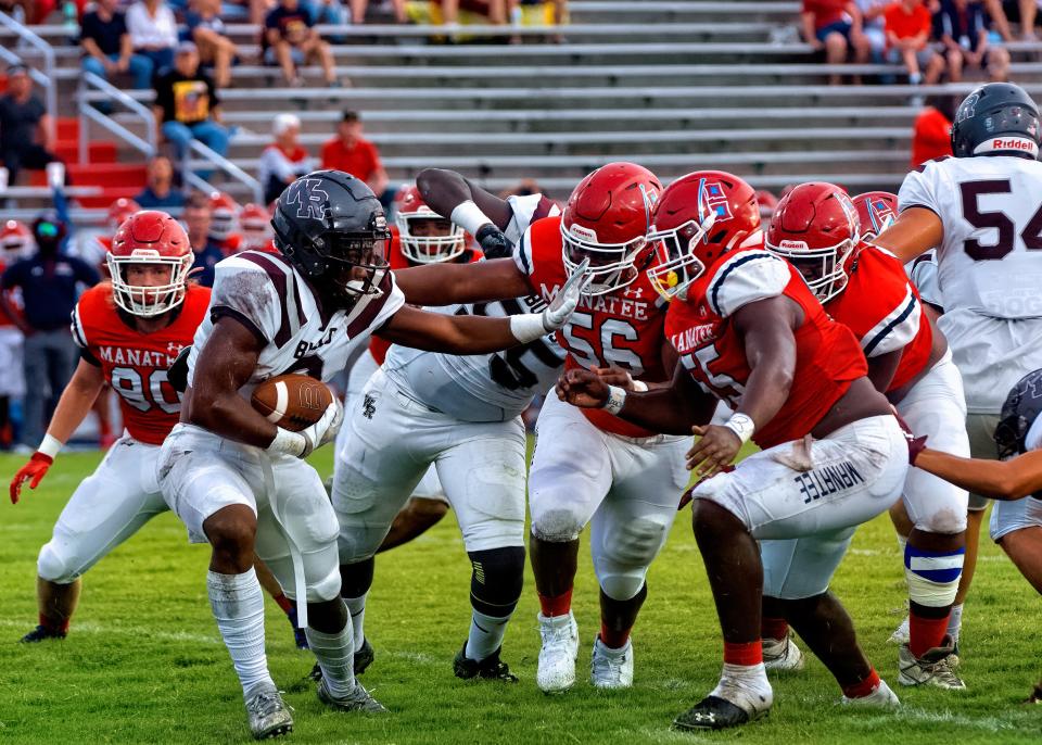 Manatee High's Ean Johnson-Kelly and Alvoid Kennon swarm Wiregrass Ranch  back Kenneth Walker during the first quarter on Friday, Aug. 26, 2022. 