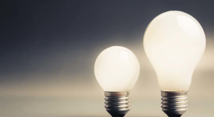 energy stocks: two light bulbs with grey sky in the background