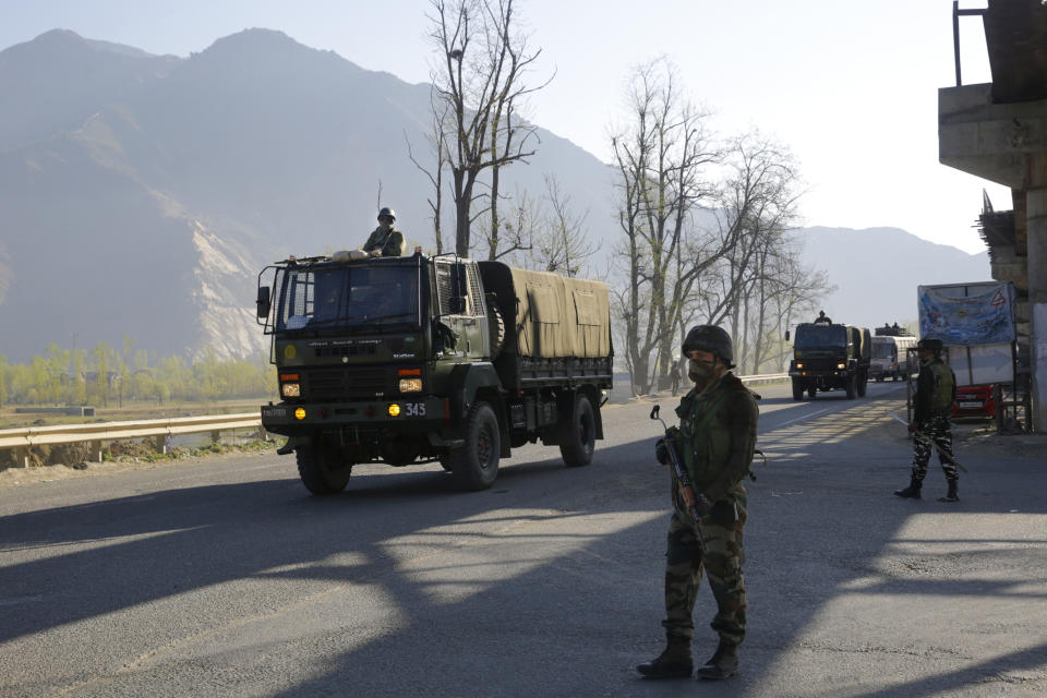 An Indian army soldier stands guard as an army convoy moves on a highway on the outskirts of Srinagar, Indian controlled Kashmir, Sunday, Feb. 7, 2019. Authorities in Indian portion of Kashmir have banned civilian traffic on Srinagar-Jammu national highway for two days in a week for the safe passage of Indian security force convoys. The move comes after the February 14 suicide bombing on a paramilitary convoy which killed more than 40 paramilitary personnel. (AP Photo/Dar Yasin)