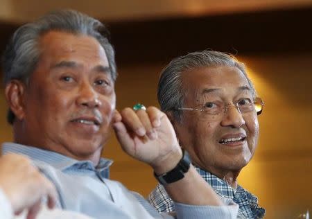 Malaysia's former Deputy Prime Minister Muhyiddin Yassin (L) and former Prime Minister Mahathir Mohamad listen to speeches during a meeting of political and civil leaders looking to change the government in Kuala Lumpur, Malaysia, March 27, 2016. REUTERS/Olivia Harris/Files
