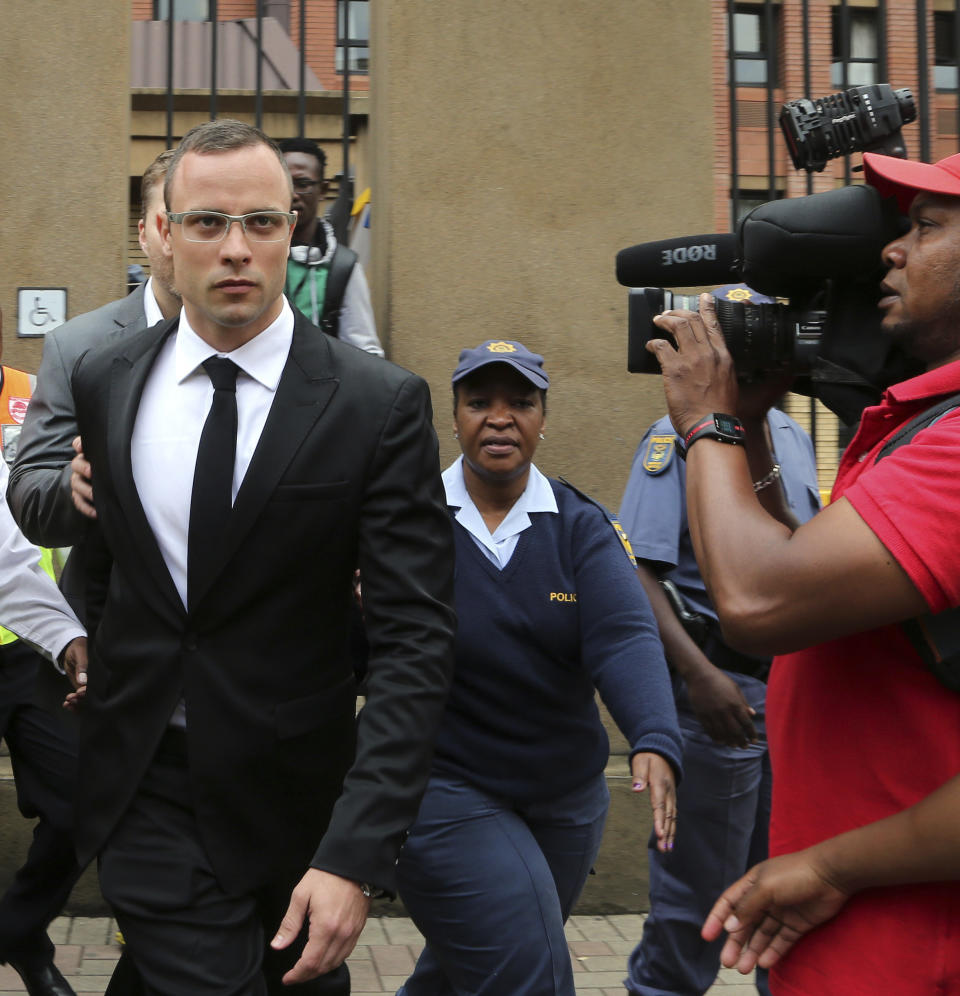 Oscar Pistorius, left, leaves the high court in Pretoria, South Africa, Friday, March 28, 2014. The murder trial of Pistorius has been delayed until April 7 because one of the legal experts who will assist the judge in reaching a verdict is sick, the judge said Friday. Pistorius is charged with murder for the shooting death of his girlfriend, Reeva Steenkamp, on Valentines Day in 2013. Pistorius is charged with murder for the shooting death of his girlfriend, Reeva Steenkamp, on Valentines Day in 2013. (AP Photo/Themba Hadebe)