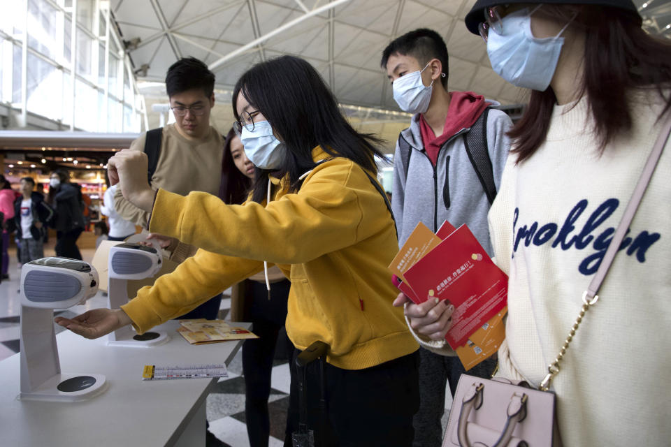 Travelers wearing face masks gather at Hong Kong International Airport in Hong Kong, Tuesday, Jan. 21, 2020. Face masks sold out and temperature checks at airports and train stations became the new norm as China strove Tuesday to control the outbreak of a new coronavirus that has reached four other countries and territories and threatens to spread further during the Lunar New Year travel rush. (AP Photo/Ng Han Guan)