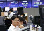 Currency traders watch monitors at the foreign exchange dealing room of the KEB Hana Bank headquarters in Seoul, South Korea, Monday, July 15, 2019. Shares are mixed in Asia, led by gains in Chinese markets after the government reported that the economy grew at the slowest pace in a decade in the last quarter. (AP Photo/Ahn Young-joon)